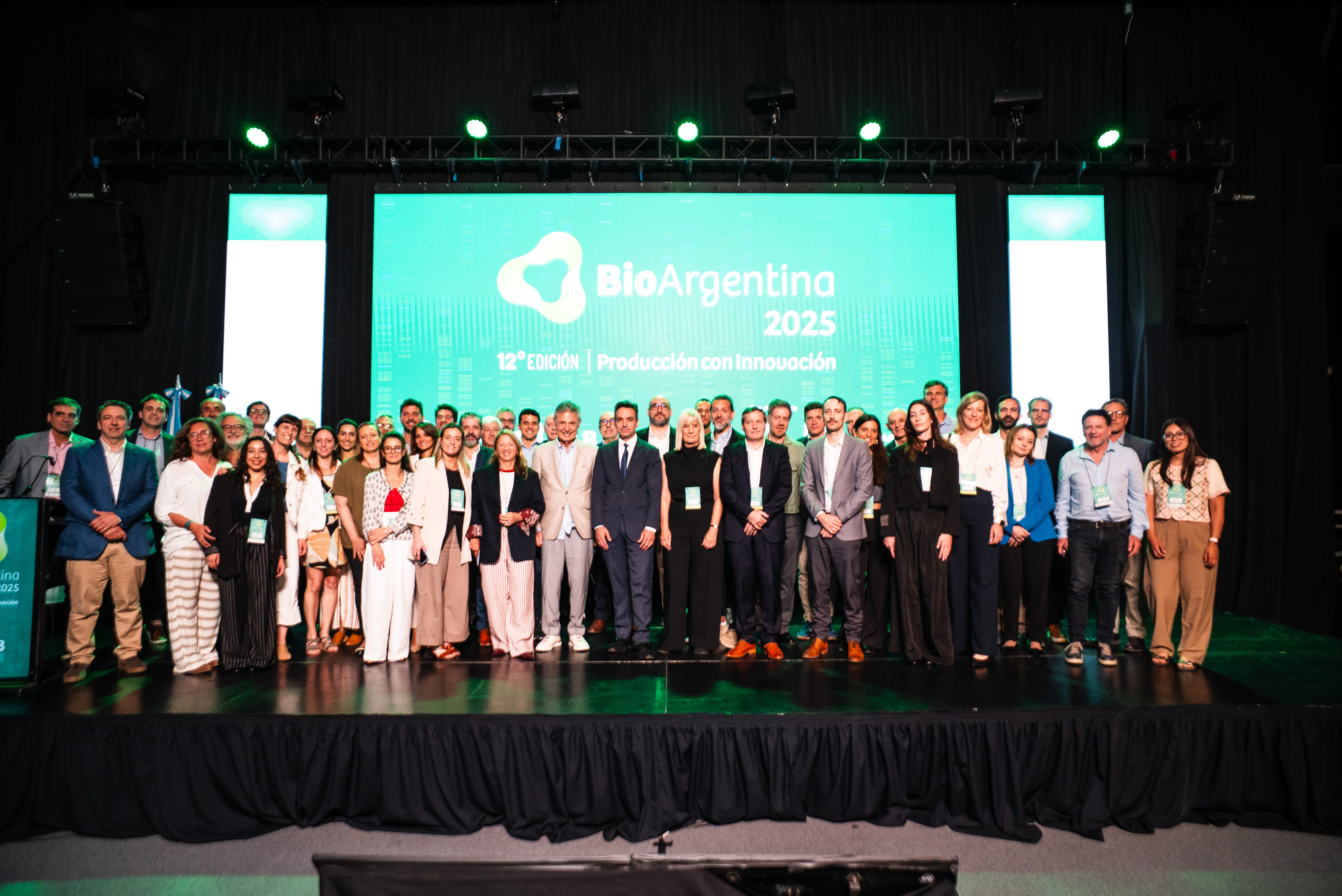 Foto grupal de participantes, autoridades y representantes del ecosistema biotecnológico durante el cierre de BioArgentina 2025 en Paraná, frente al escenario principal con la gráfica del evento.